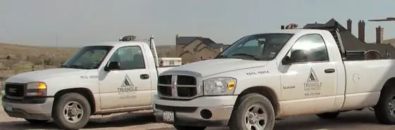 Two Triangle Electric Company pickup trucks with the company logo on the doors